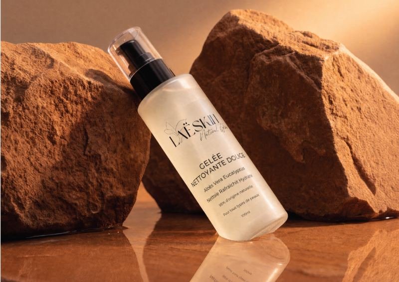 Flacon de gelée nettoyante Laëskin posé entre des roches couleur sable
