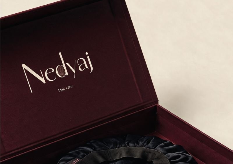 Coffret Nedyaj bordeaux ouvert sur un tissu satiné